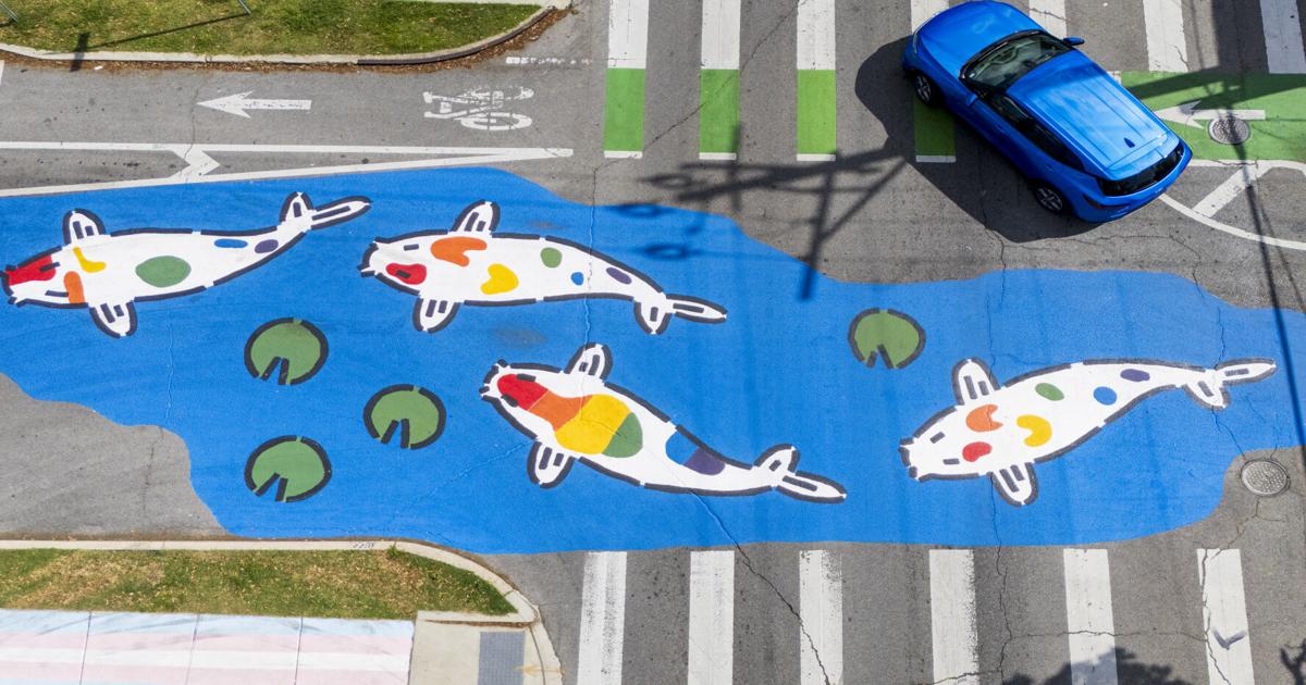 Aerial view of Jeremy Novy rainbow koi fish mural painted across Elysian Fields Avenue